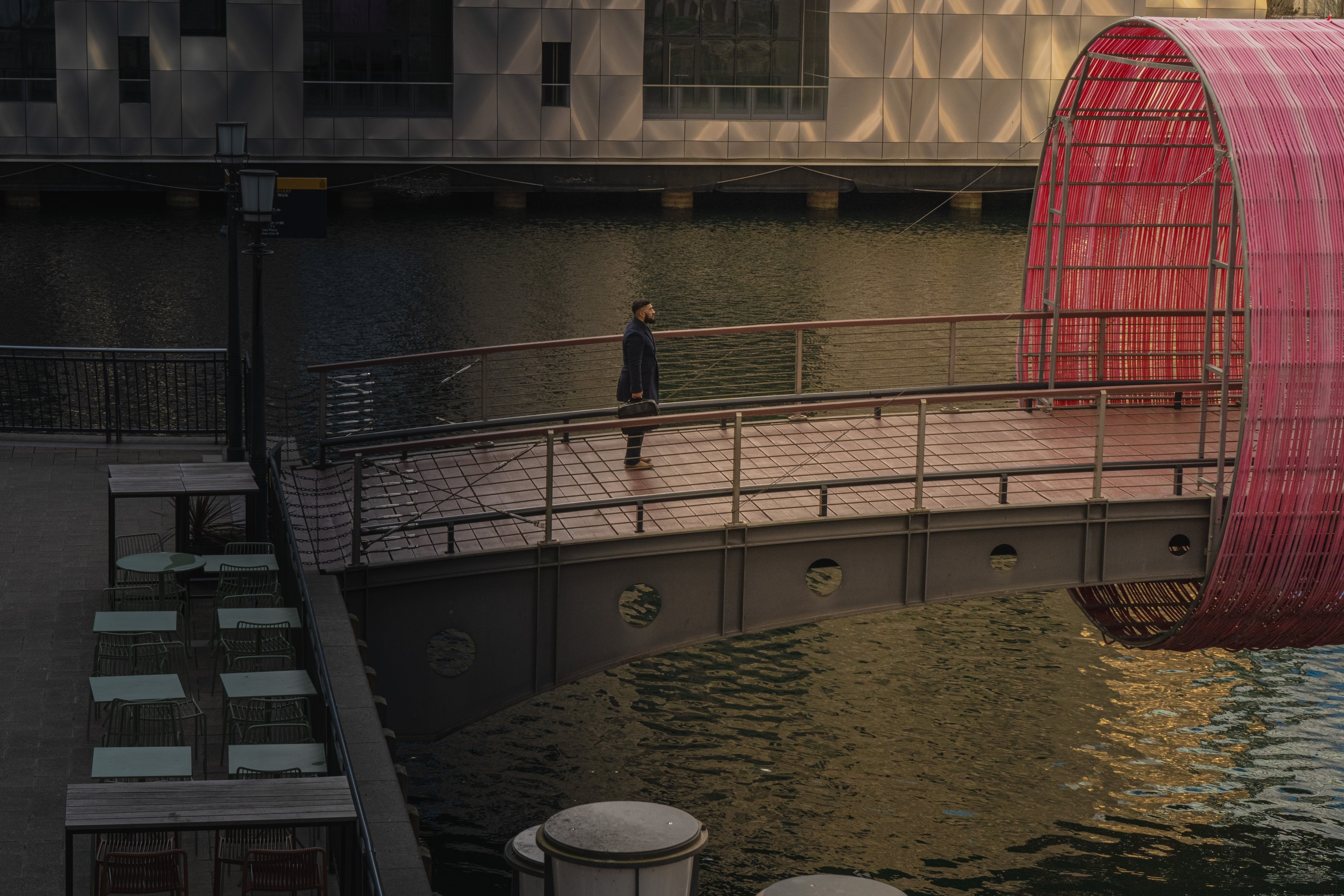 Man carries briefcase on bridge